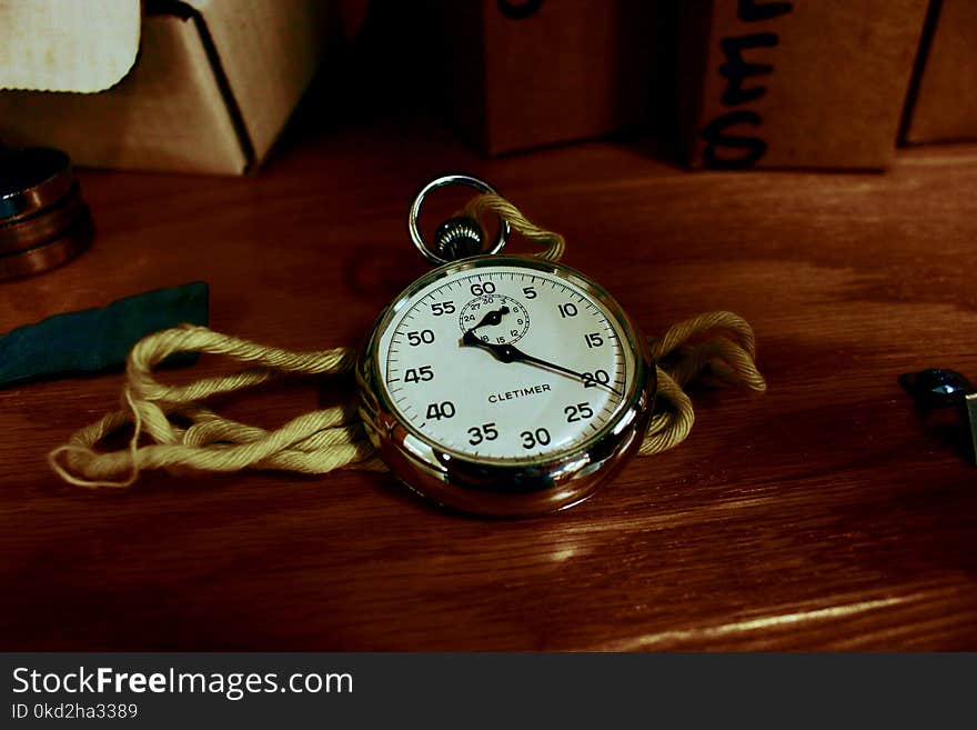 White Pocket Watch With Gold-colored Frame on Brown Wooden Board