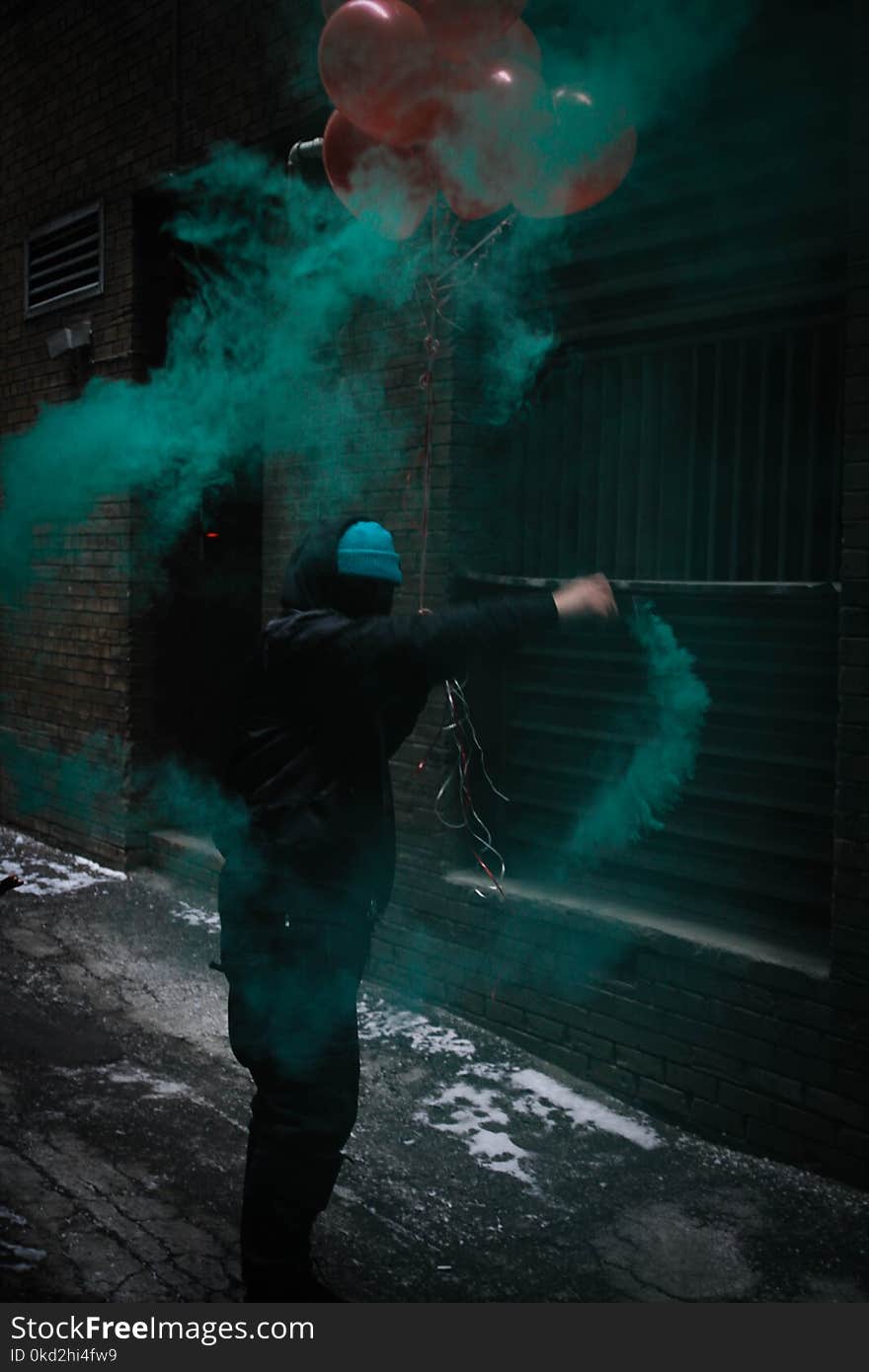 Person Wearing Black Jacket Holding Red Balloons