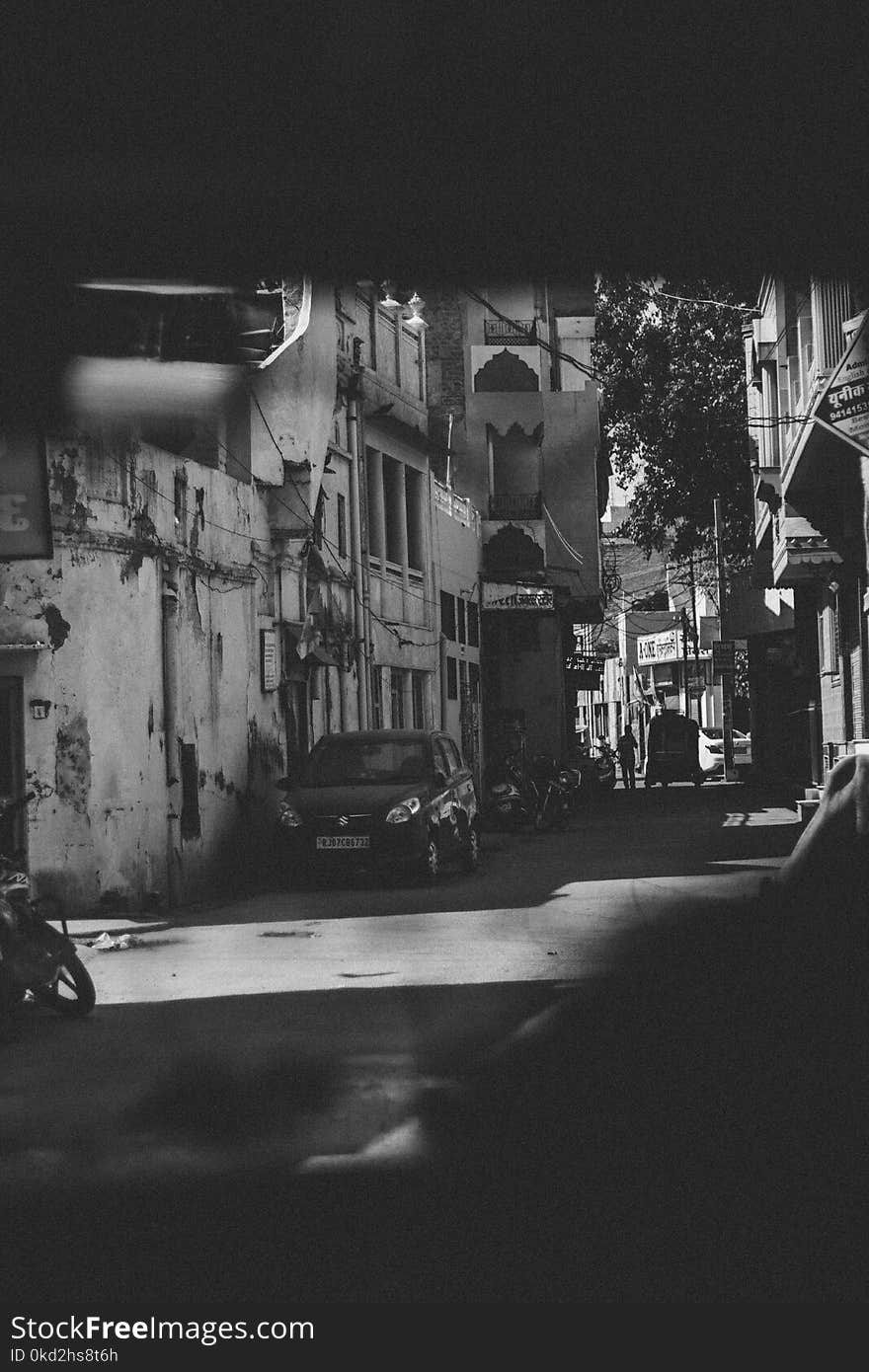 Grayscale Photography of Car and Motorcycle Beside Building