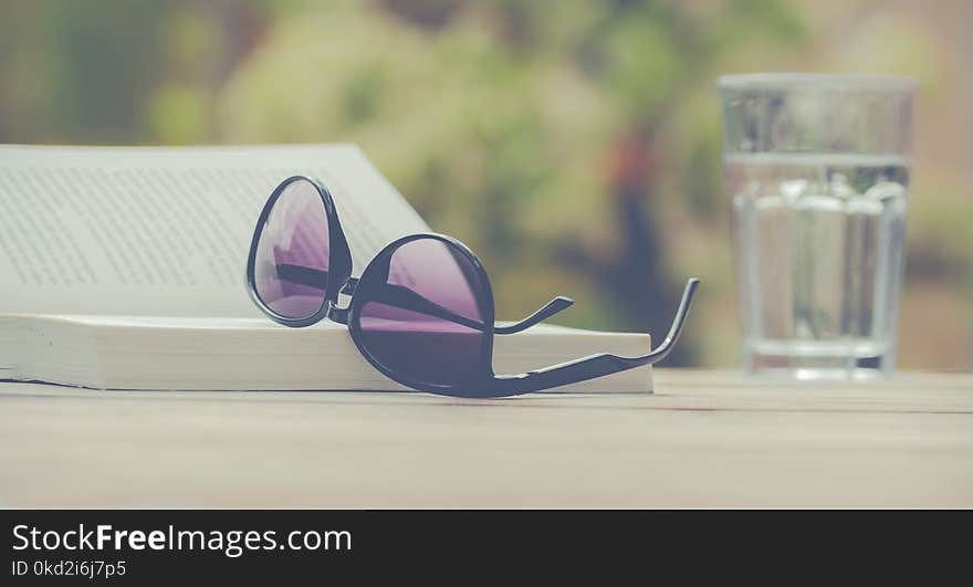 Photography of Sunglasses Near Book