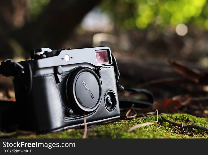 Selective Focus Photo of Black Fujifilm Camera on Ground