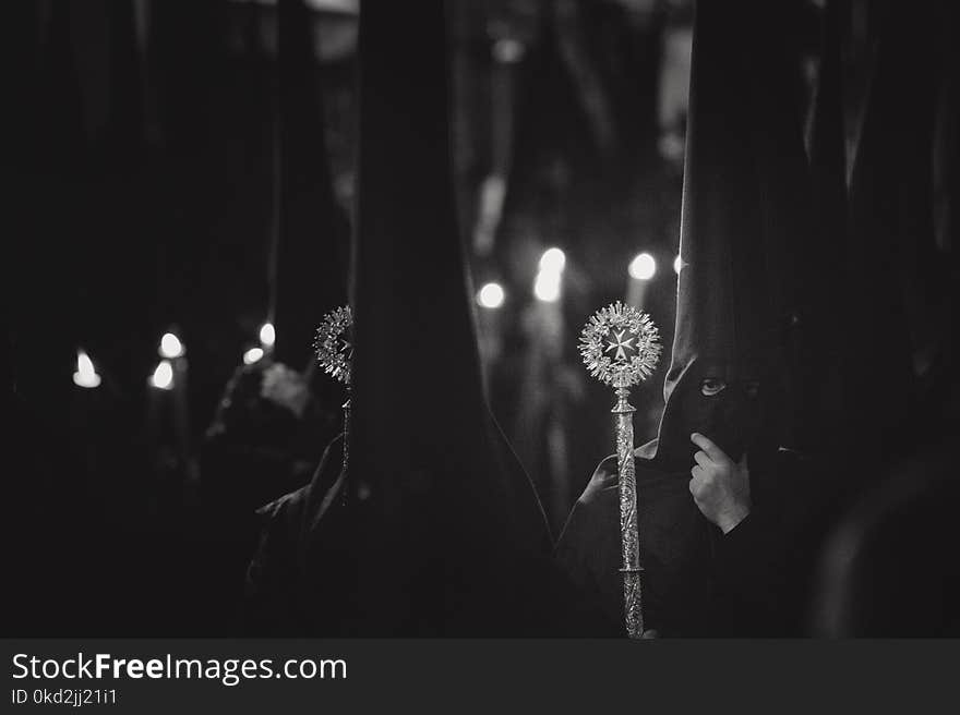 Grayscale Photo of Person Wearing Balaclava Holding Wand