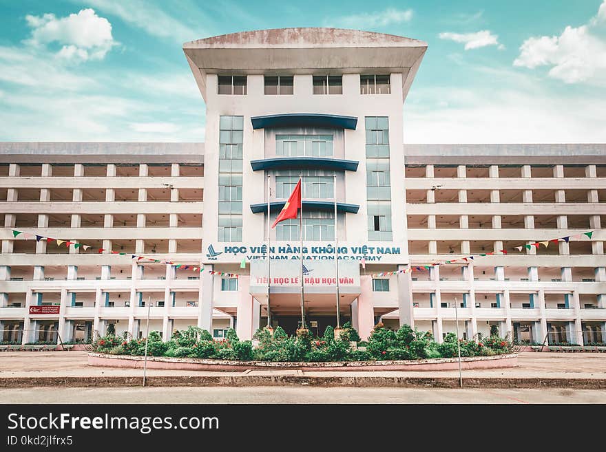 White Concrete Building With Red Flag Outside