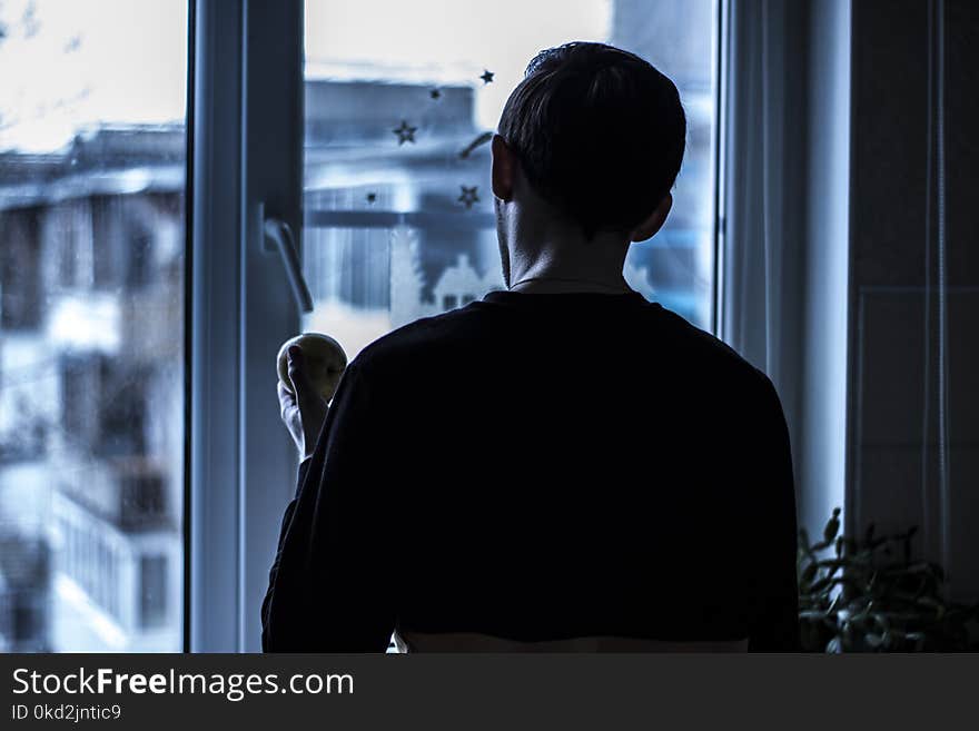 Man Looking Outside Near Clear Glass Window