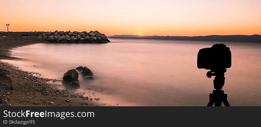 Camera On Tripod With Sunset Over The Sea In Background / Podgora, Croatia