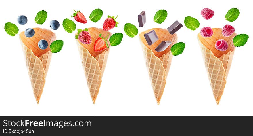 Variation of waffle cones with flying berries and chocolate slices