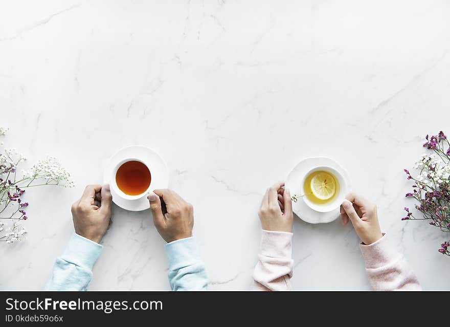 Person Holding Ceramic Teacups