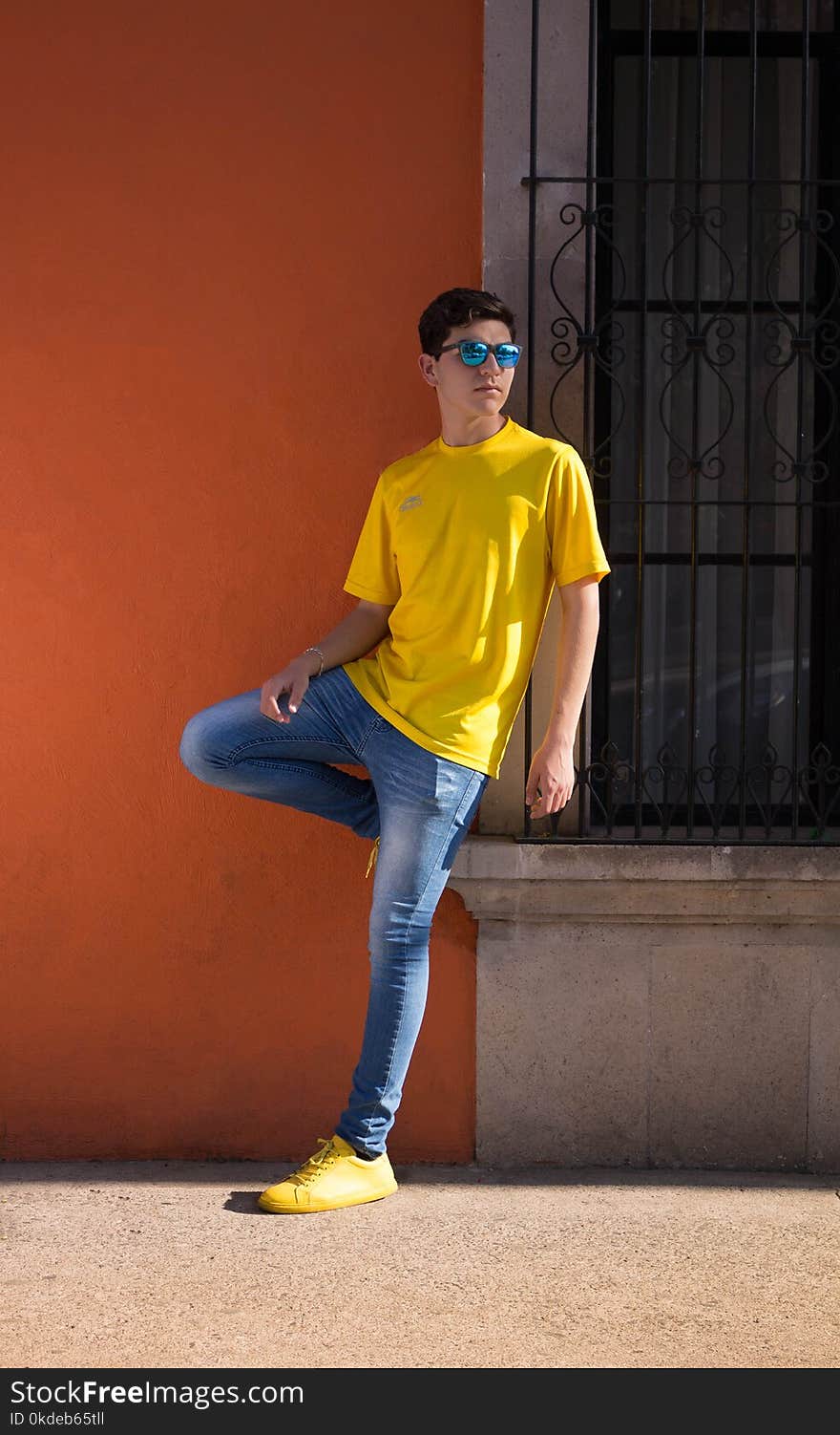 Man Wearing Yellow Crew-neck T-shirt and Blue Denim Jeans