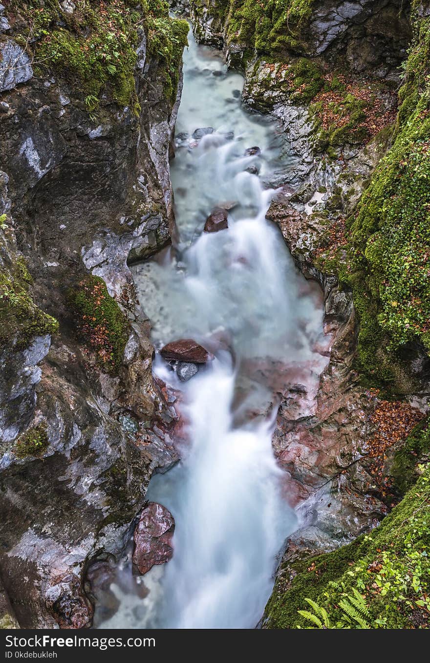 Body of Water Between Cliffs Covered With Moss