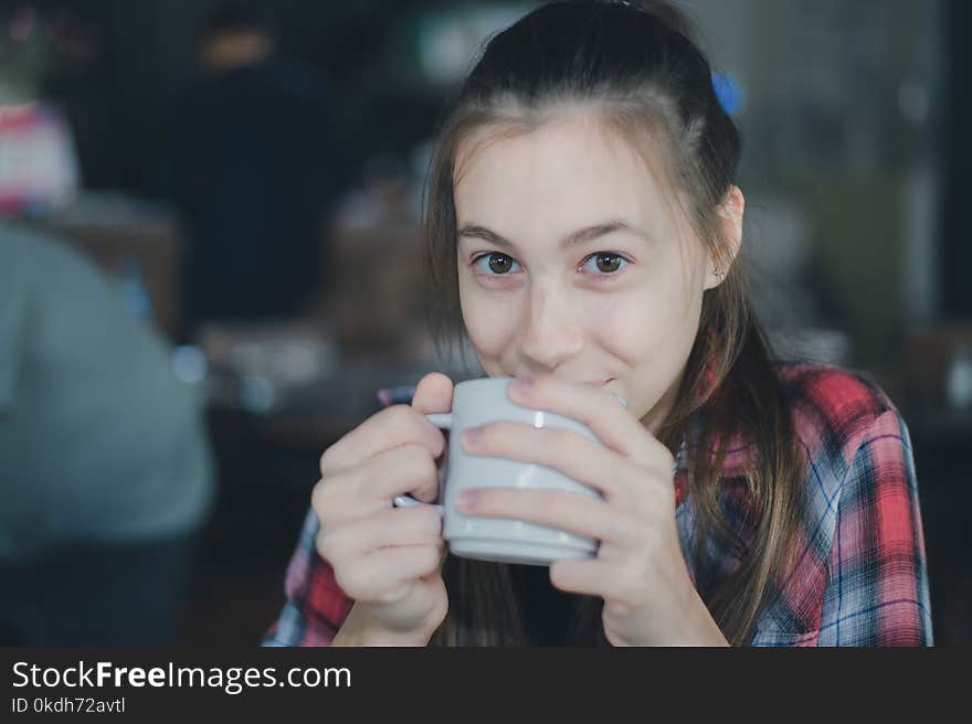 Beautiful caucasian woman holding a cup of coffee in her hand on blurred background