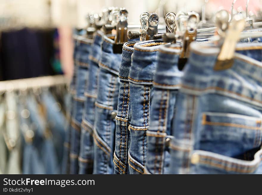 Set of blue jeans hanging on hangers in shop