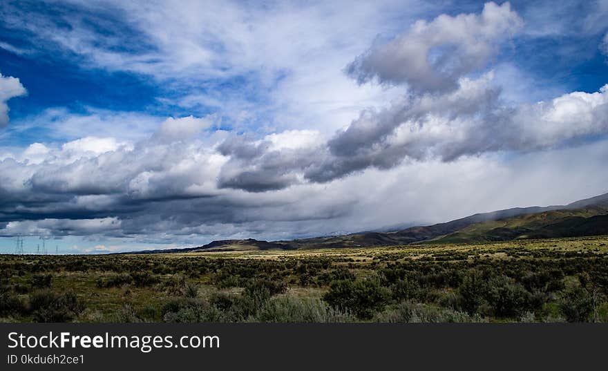 Landscape Photography of Green Field Under Cloudy Sky