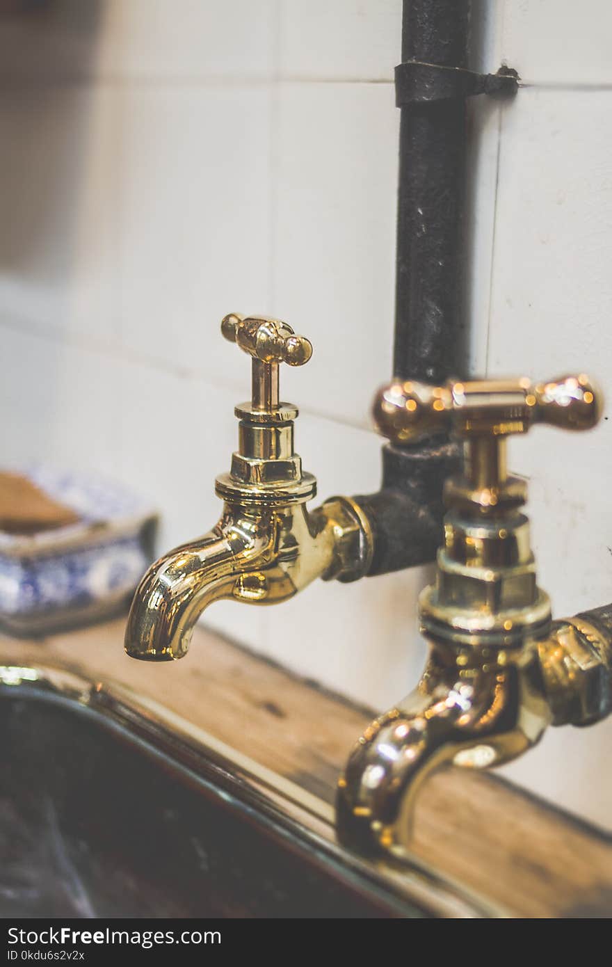 Shallow Focus Photography of Gold Faucets