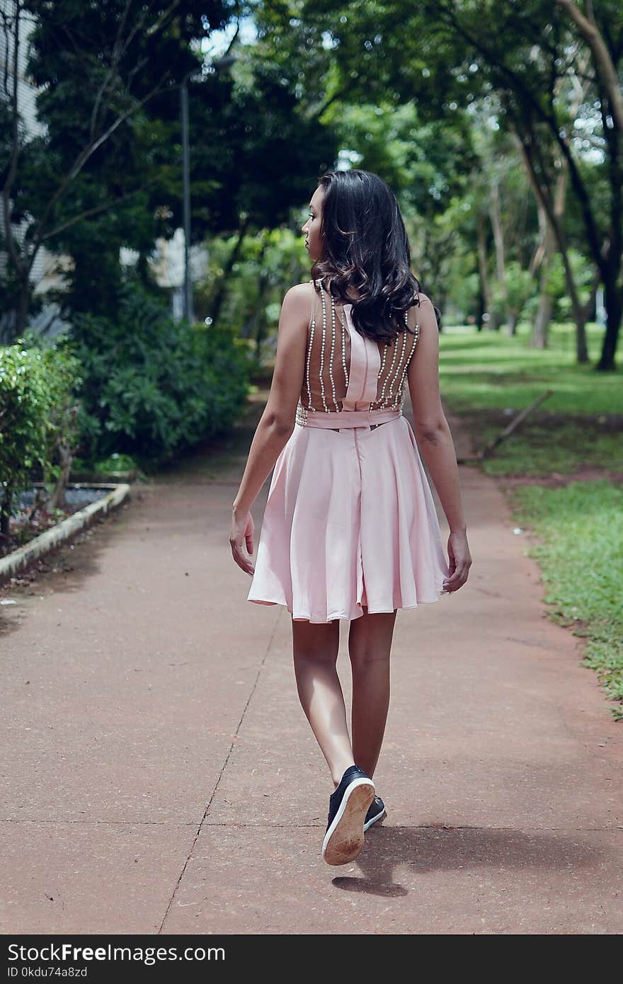 Woman Wearing Pink Mini Dress Walking on Walkway