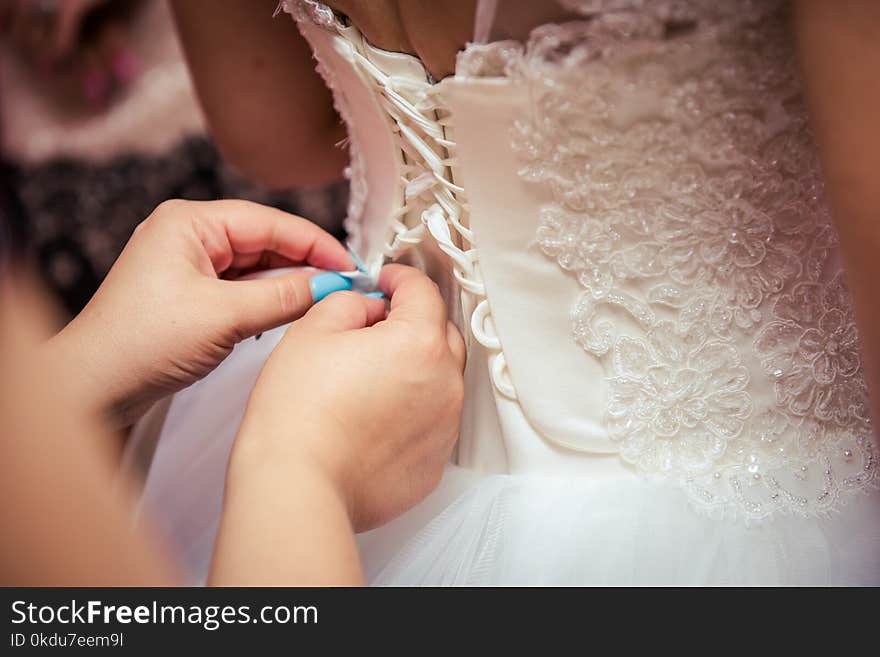 Photo of Woman Fixing the Wedding Gown