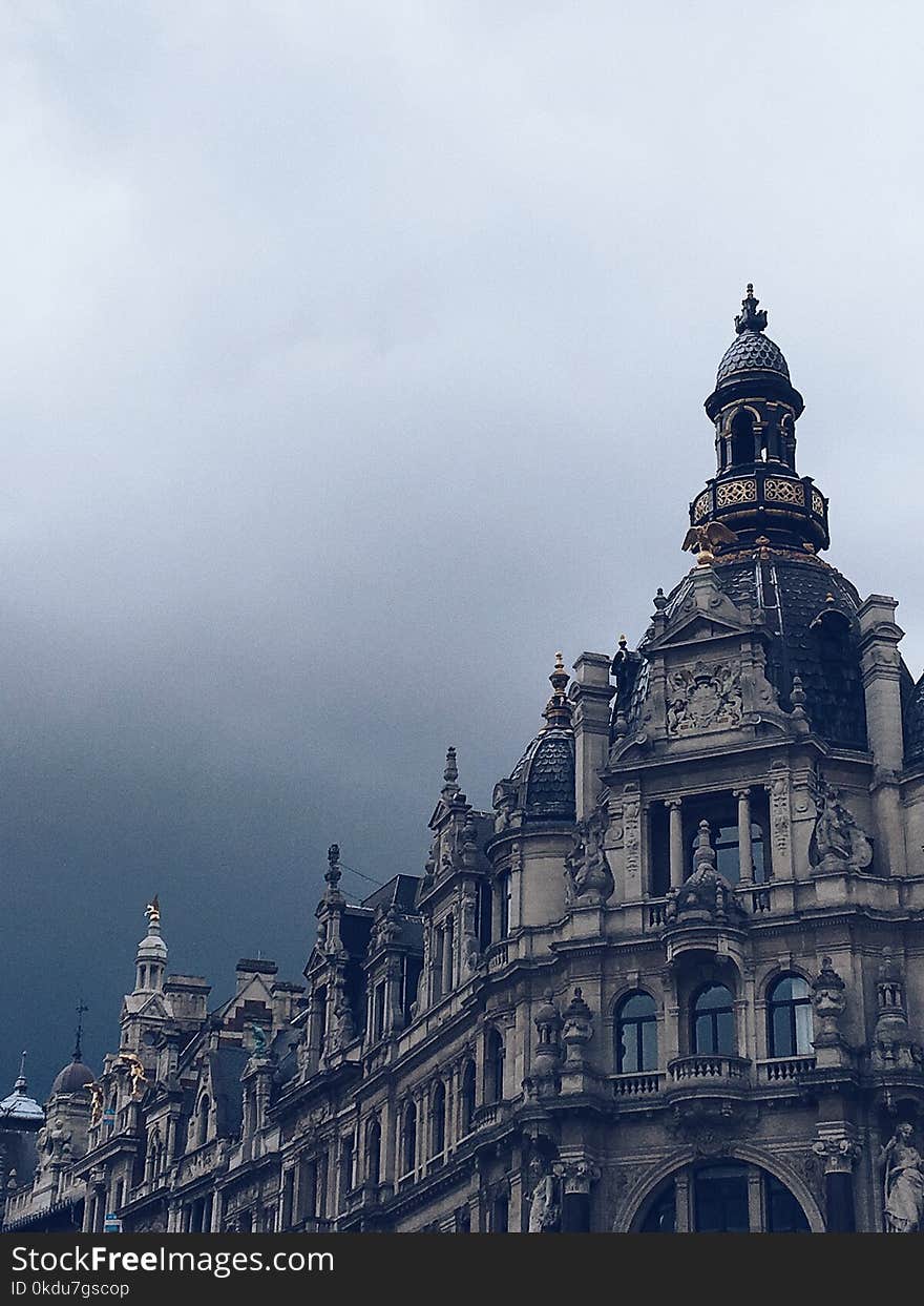 Beige Concrete Building and White Clouds