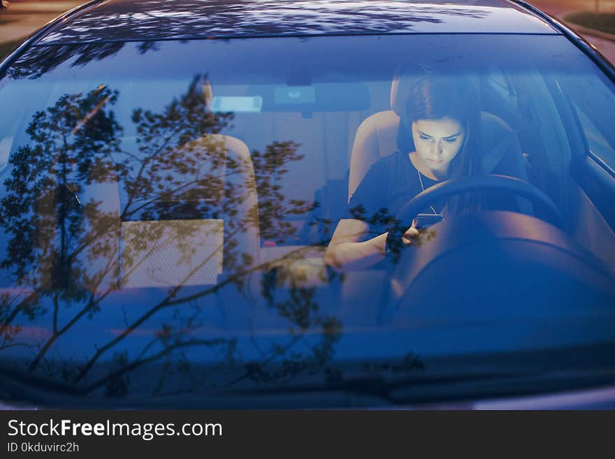 Beautiful girl model sitting in the car and use the phone. Beautiful girl model sitting in the car and use the phone