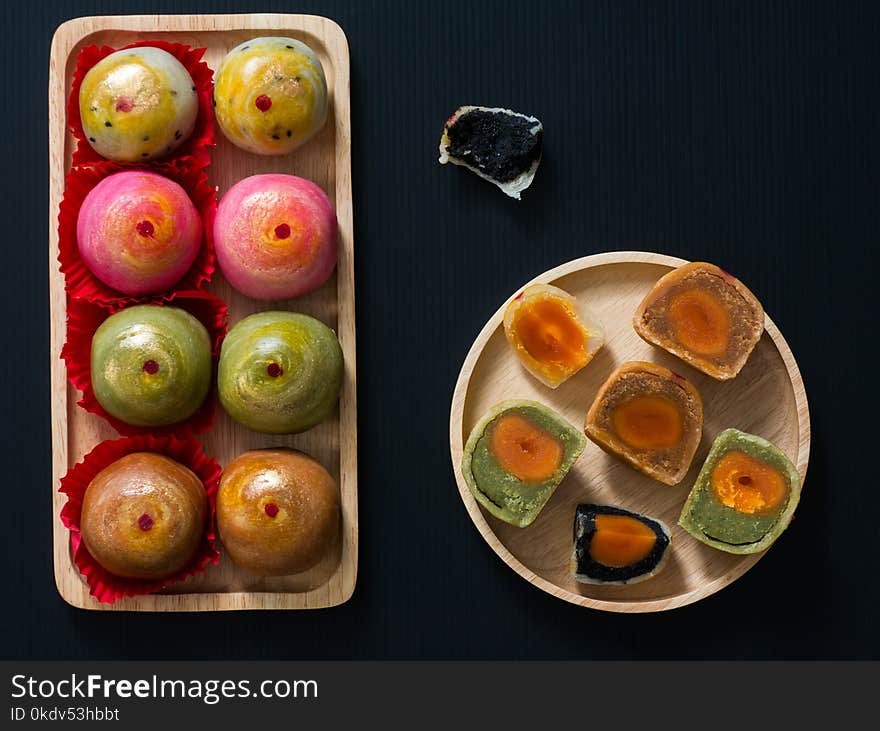 Closeup chinese cake in wooden plate on dark background. Closeup chinese cake in wooden plate on dark background