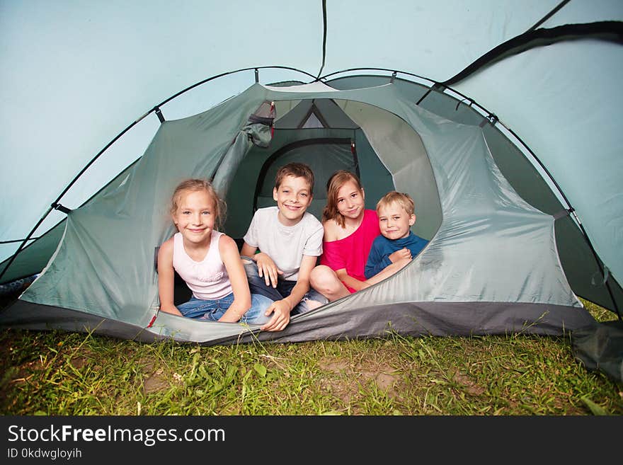 Children in a tent. Camping. Happy kids at summer vacations. Children in a tent. Camping. Happy kids at summer vacations