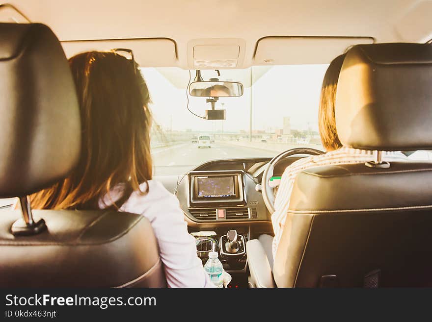 woman driving car and passenger on front seat