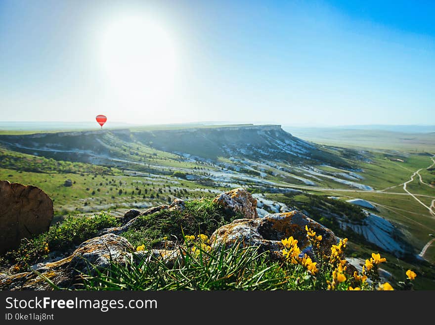 Down view form mountain valley. Natural summer landscape. Green grass and yellow flowers foreground