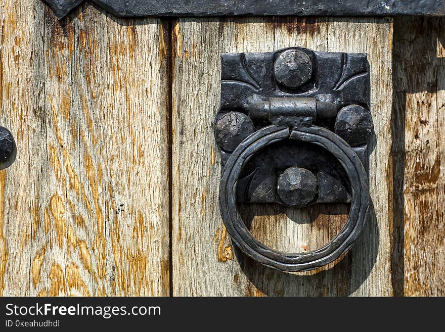 Old wooden door with aged metal door handle. Architect textured background. Close up. Retro and vintage concept image.