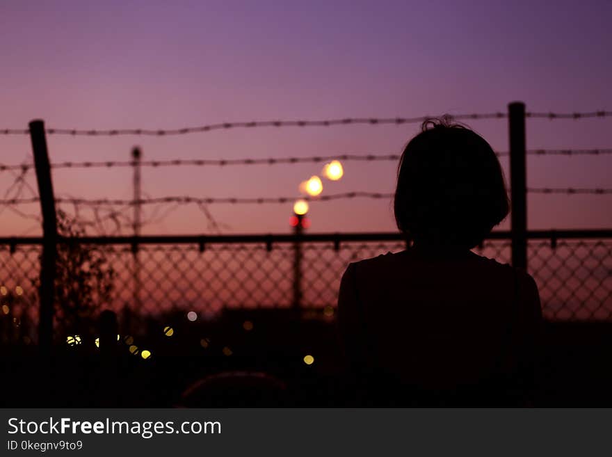 Silhouette of Person in Front of Fence