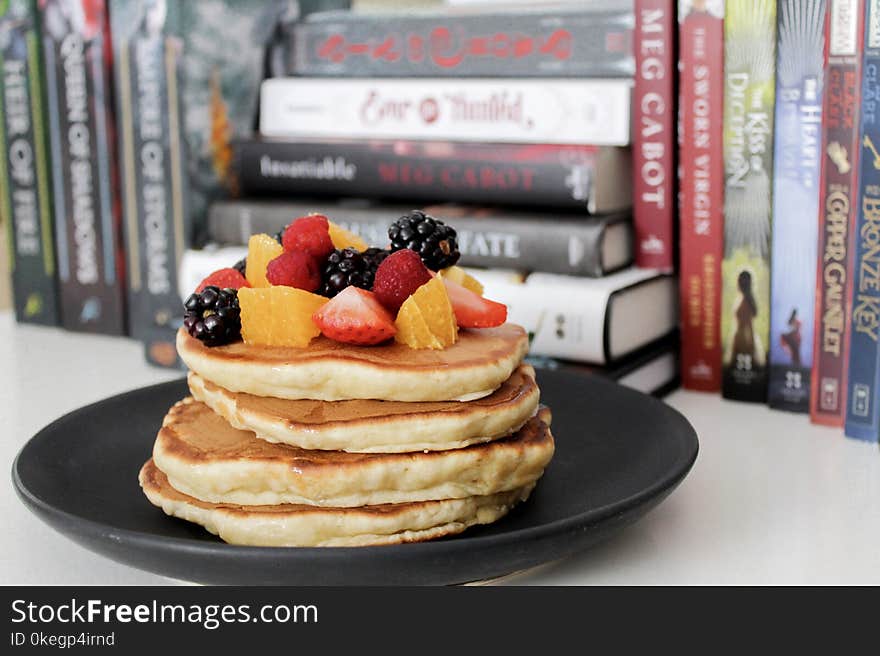 Pancake on Black Plate Near Books