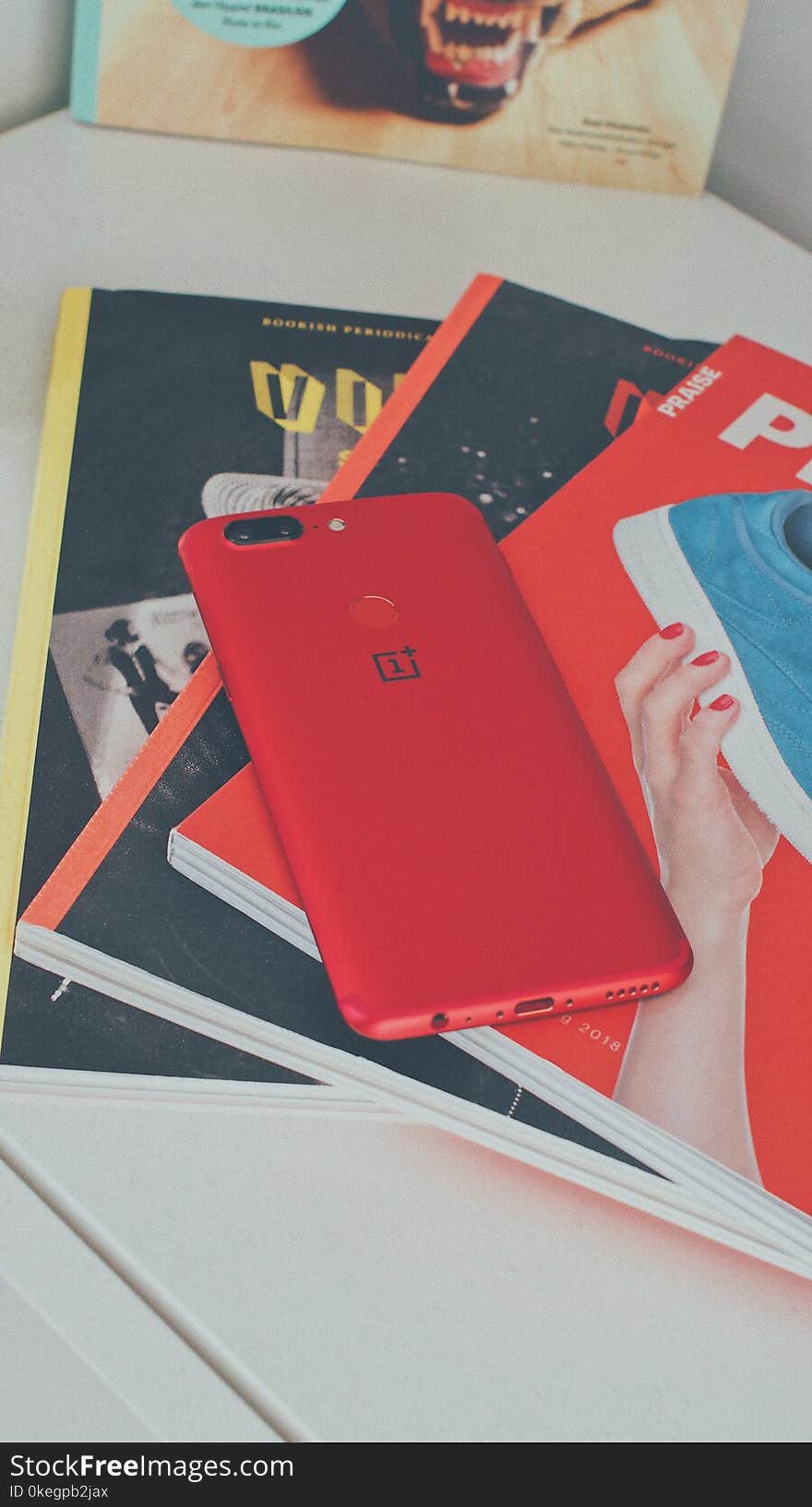 Red Oneplus Smartphone on Books