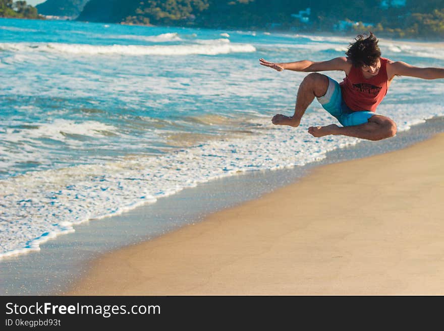 Photography of a Man Jumping on Beach