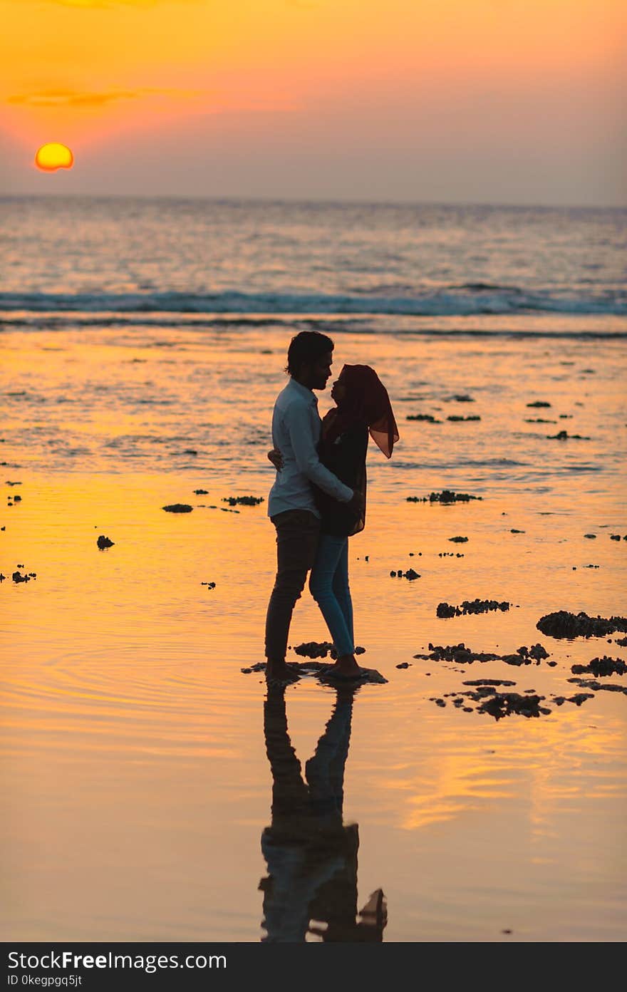 Man and Woman Hugging by the Seashore during Sunset