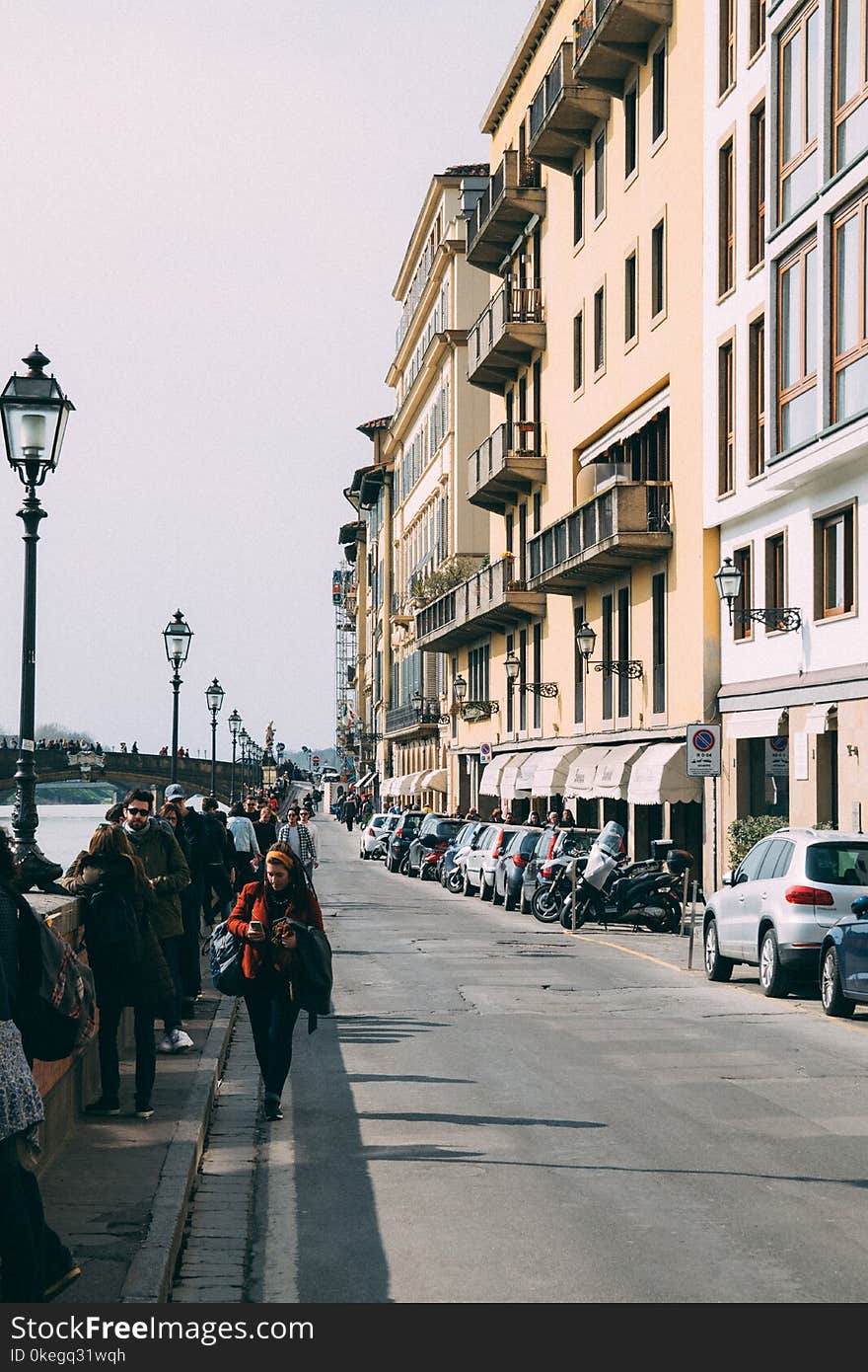 People Walking Along Pavement Near Building