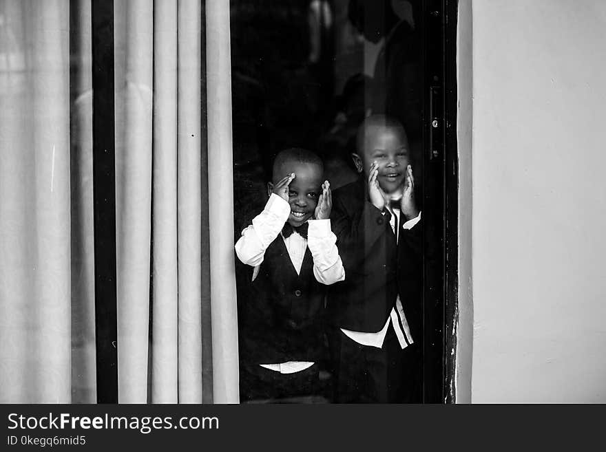 Two Boys in Front of Glass Window