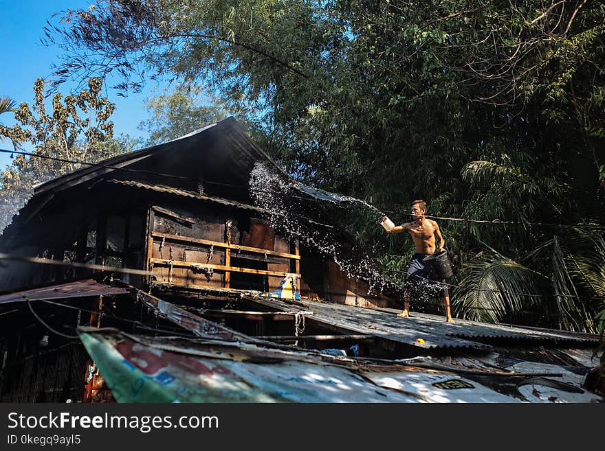 Man Throwing Water on Roof