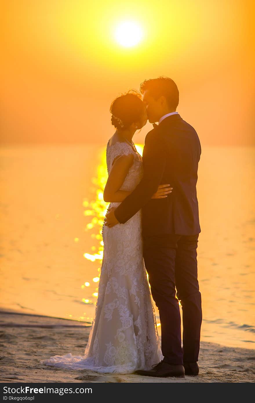 Man and Woman Kissing Under Sunset