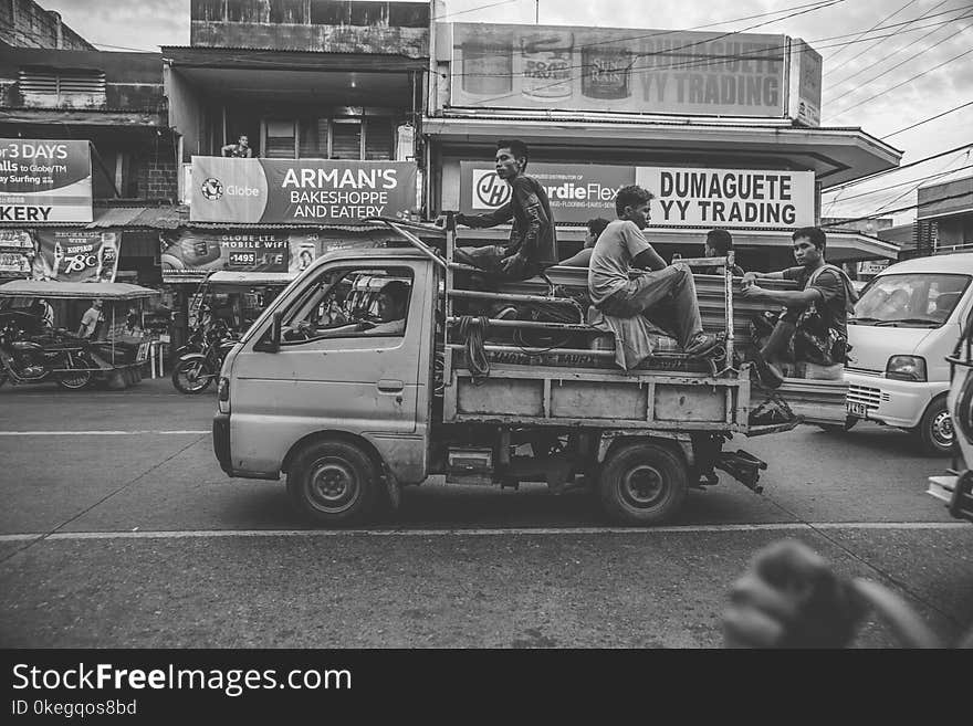 Grayscale Photo of Men Riding on Kei Truck