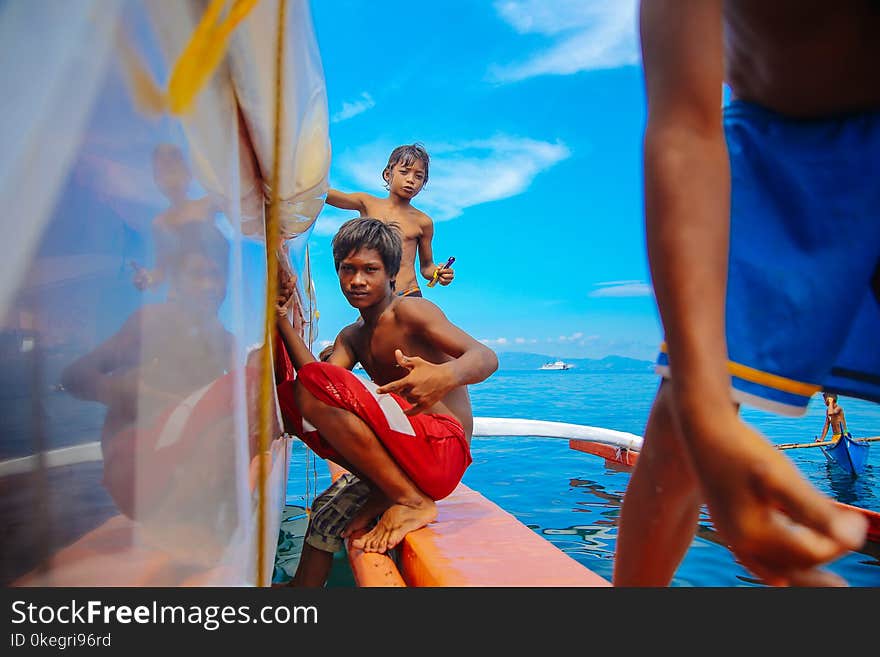 Teenage Boys Sitting on Edge of Boat