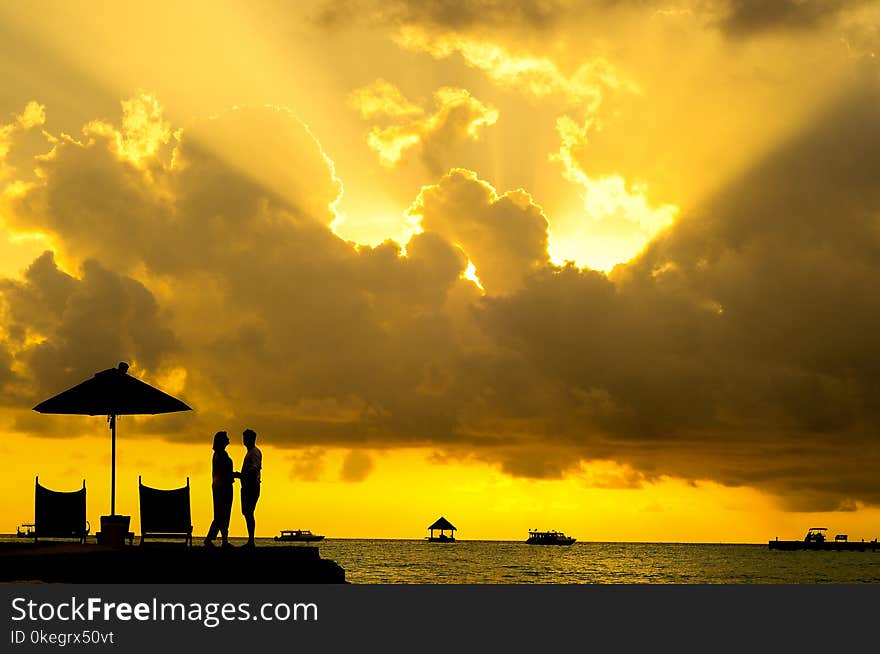 Silhouette Photo of Man and Woman Beside Body of Water during Sunset