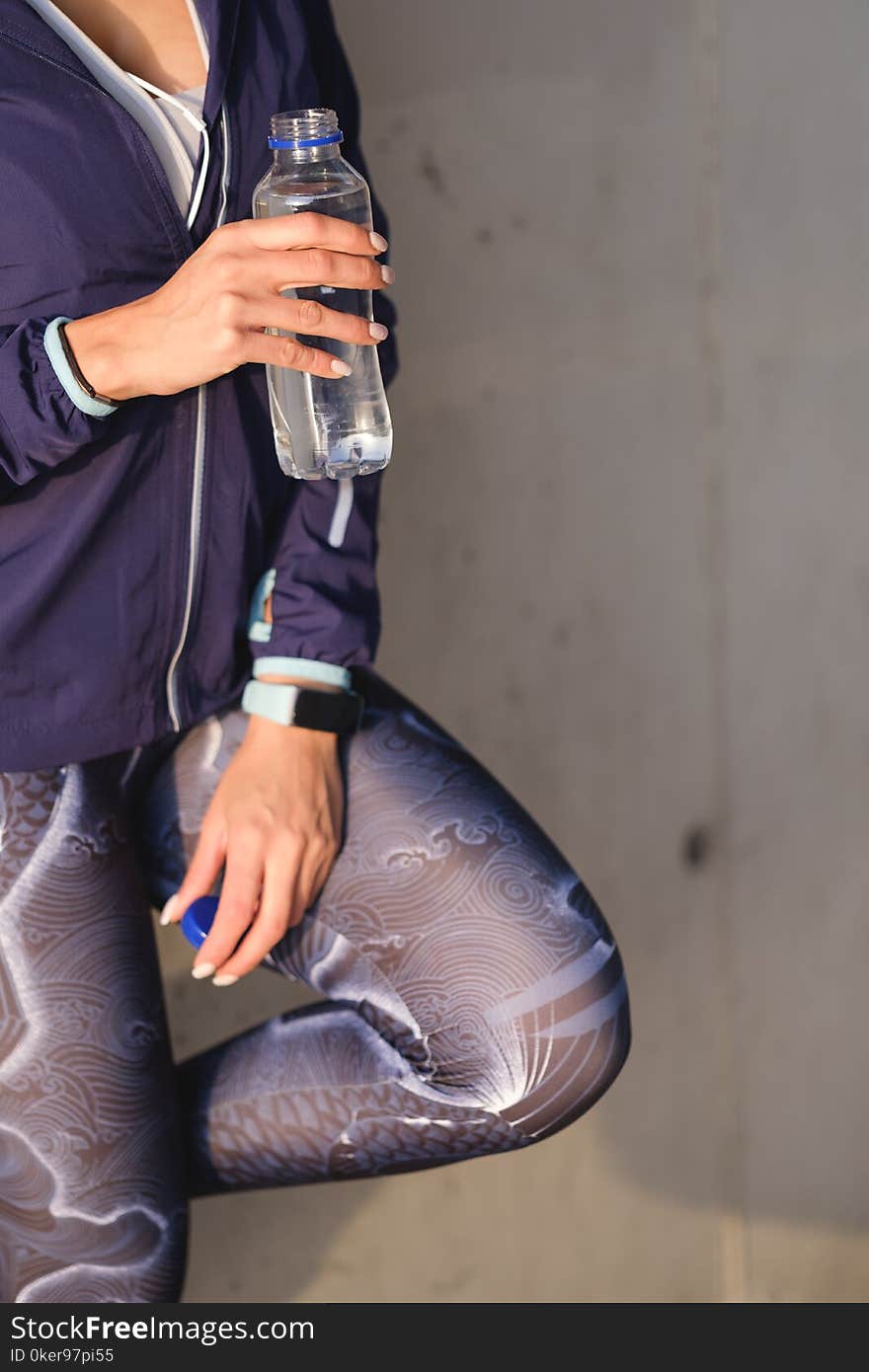 Urban fitness workout concept. Close up of woman in sportswear drinking water during training rest. Urban fitness workout concept. Close up of woman in sportswear drinking water during training rest.