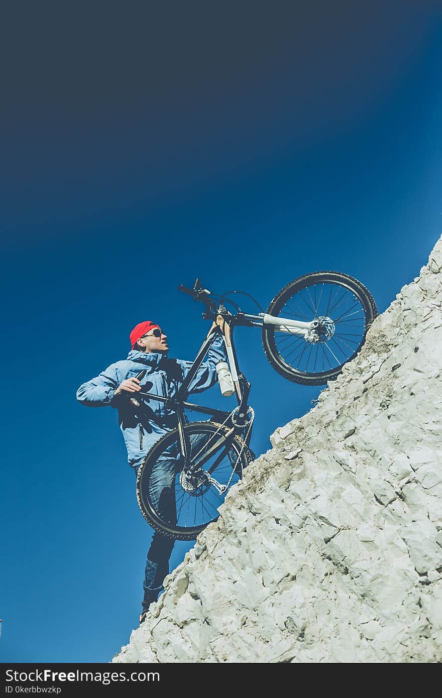 Young Guy With A Bicycle On A Chalky Mountain