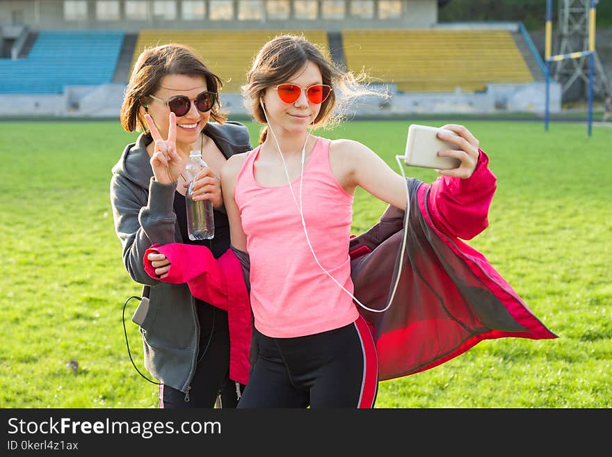 Mother and daughter teenager resting after workout at stadium. Photographed together selfi photo. Mother and daughter teenager resting after workout at stadium. Photographed together selfi photo.