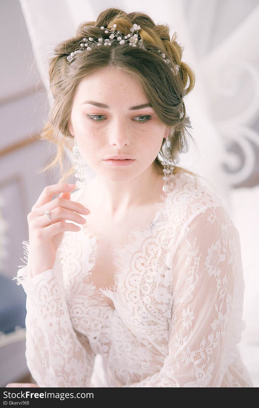 Bride with cones and fair hair. Fragile bride in white