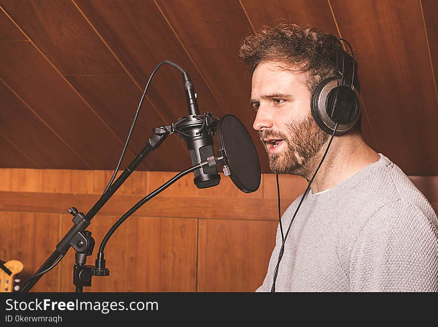 Modern boy singing with headphones in a music studio