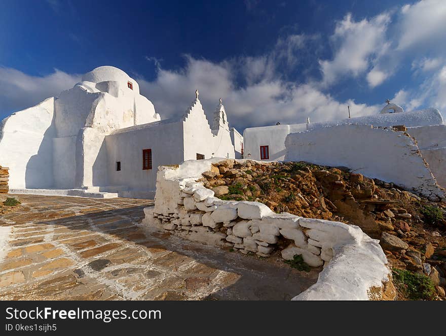 Snow-white Orthodox Church of the Holy Virgin against the blue sea. Greece. Mykonos. Chora. Snow-white Orthodox Church of the Holy Virgin against the blue sea. Greece. Mykonos. Chora.