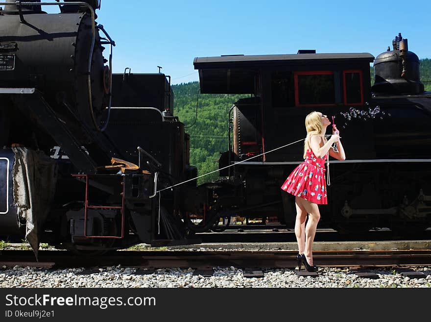 Young woman in red dress waiting at train station. Young woman in red dress waiting at train station