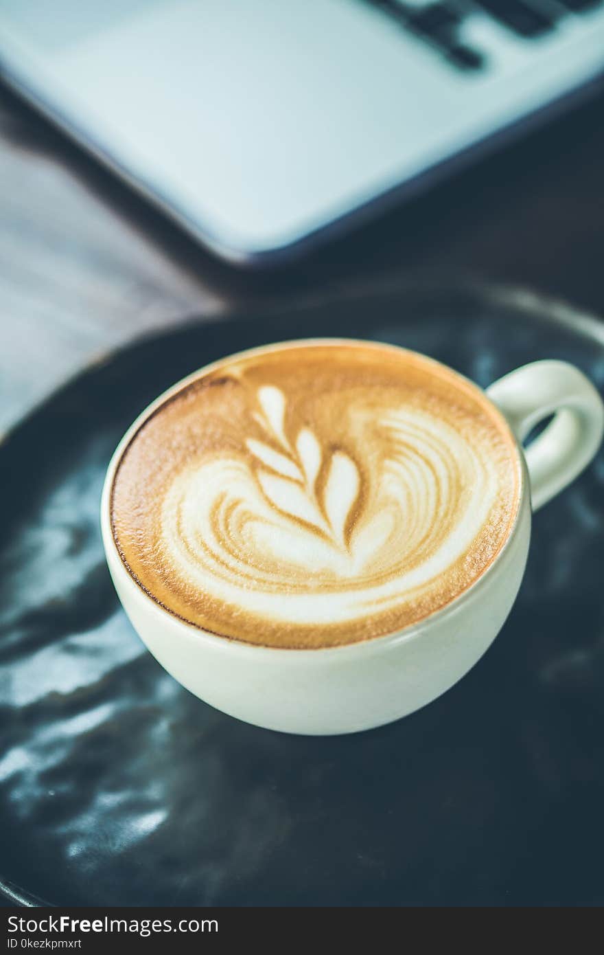 Coffee cup latte art with littlw wooden spoon.