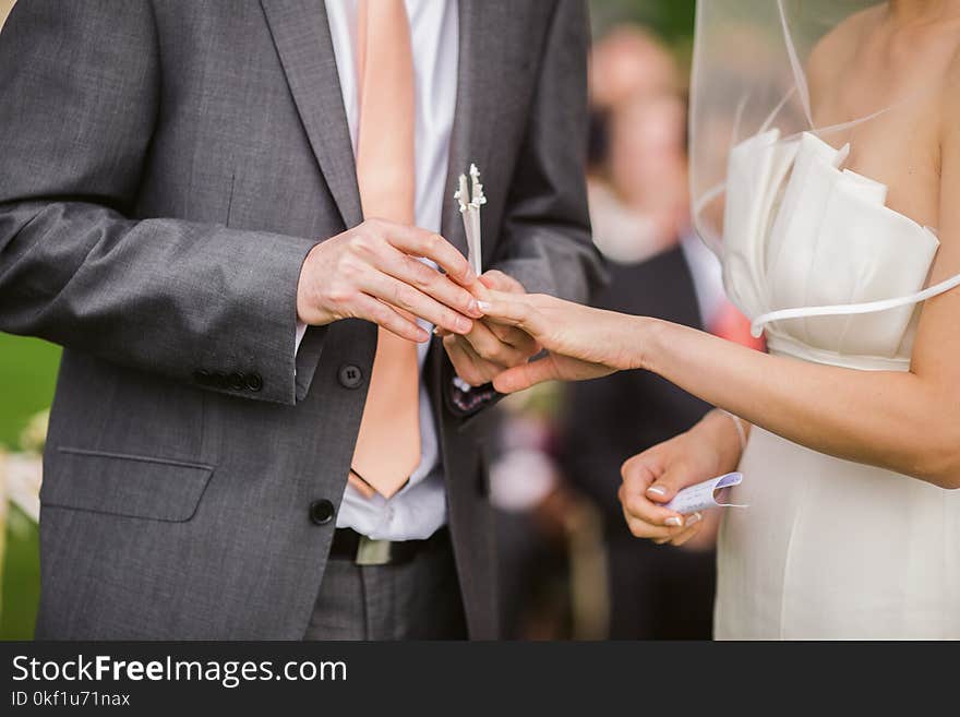 Photo of Groom Putting Wedding Ring on His Bride