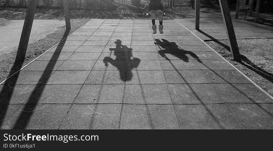 Grayscale Photo of Two Children Using Swing