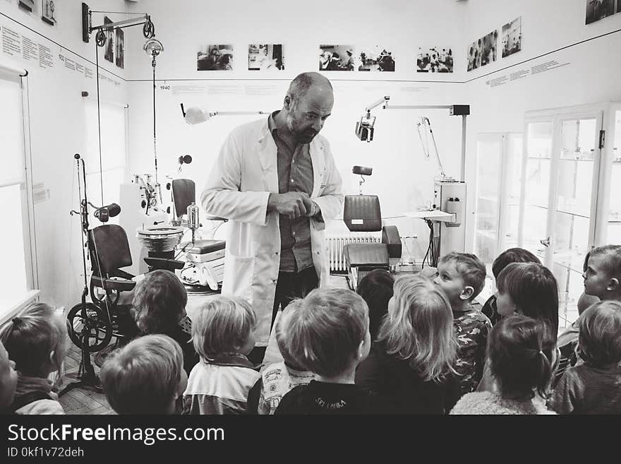 Grayscale Photo of Man Lecturing Children