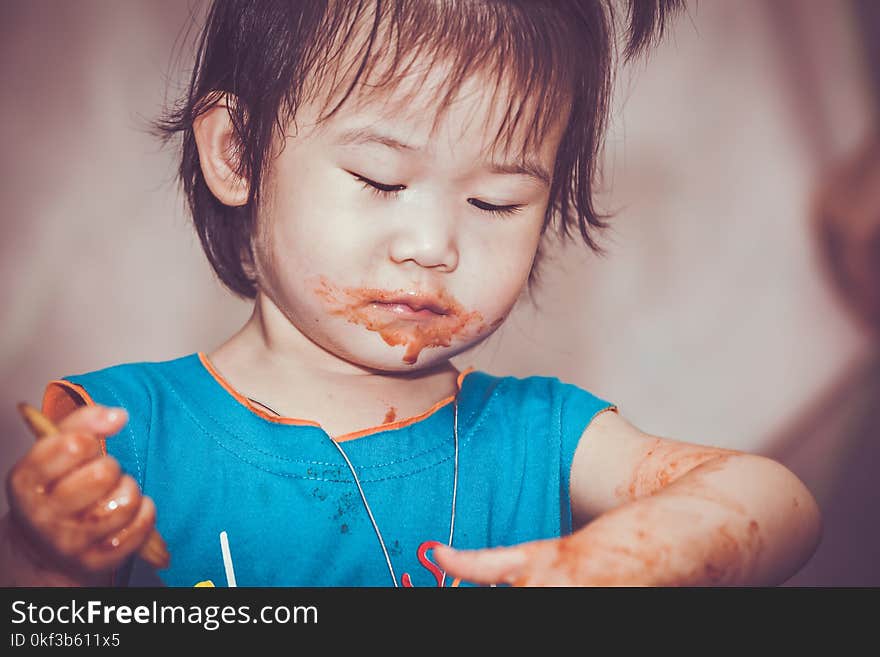 Portrait of a asian child enjoy eating. Her hand and mouth get stained with ketchup and dirty. Charming girl playing with food and learning to eat. Do it yourself concept. Portrait of a asian child enjoy eating. Her hand and mouth get stained with ketchup and dirty. Charming girl playing with food and learning to eat. Do it yourself concept.